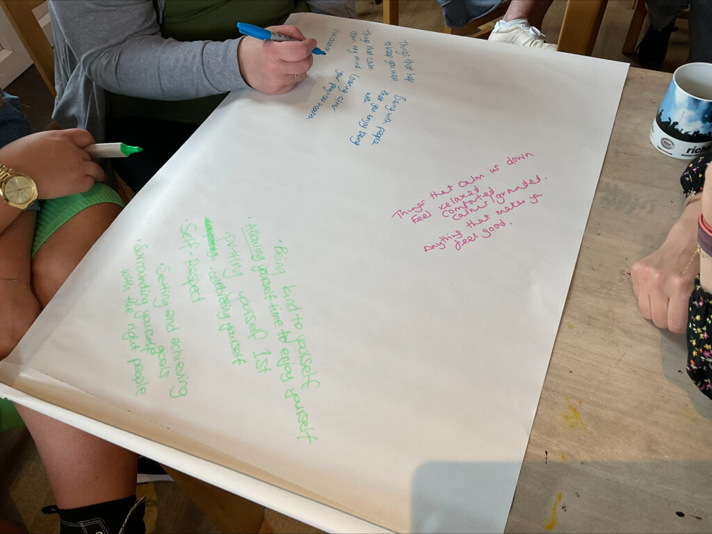 Wellbeing College students writing down ideas for self-care workshop